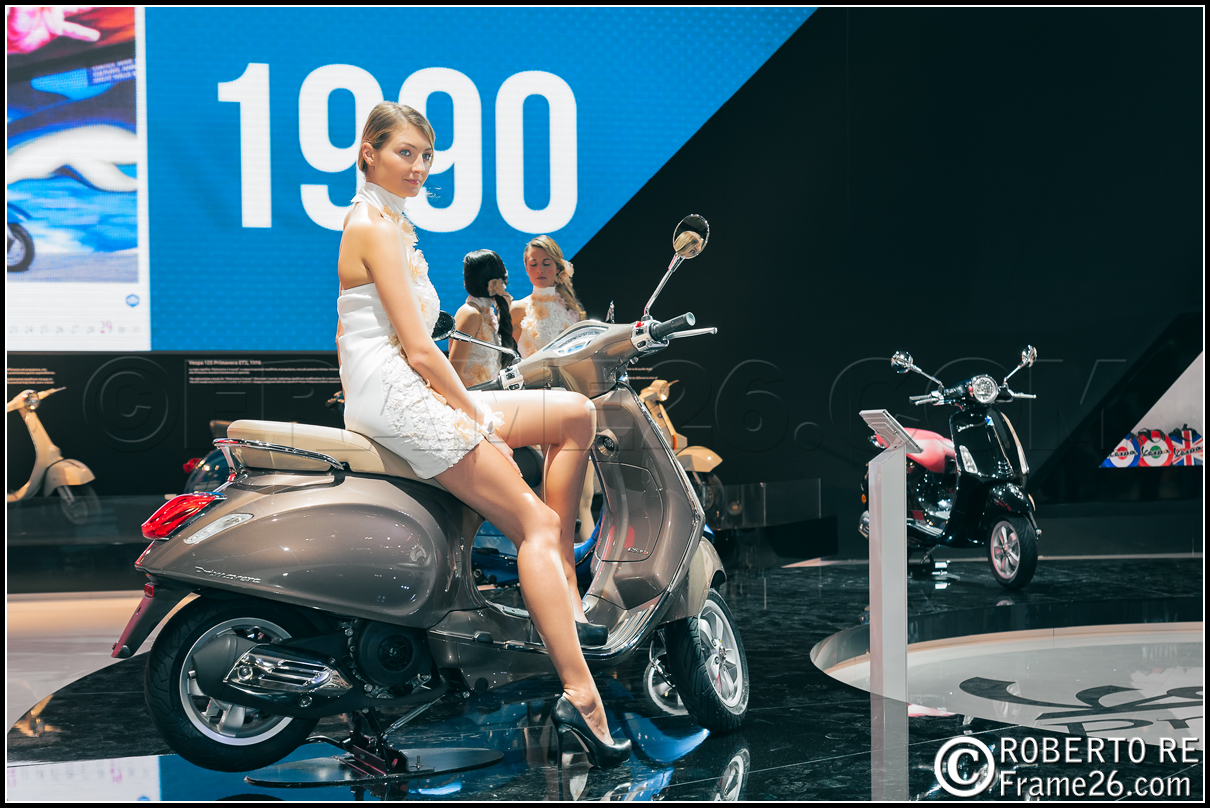 Ragazza Bionda con Minigonna e Scarpe col Tacco in sella alla Vespa